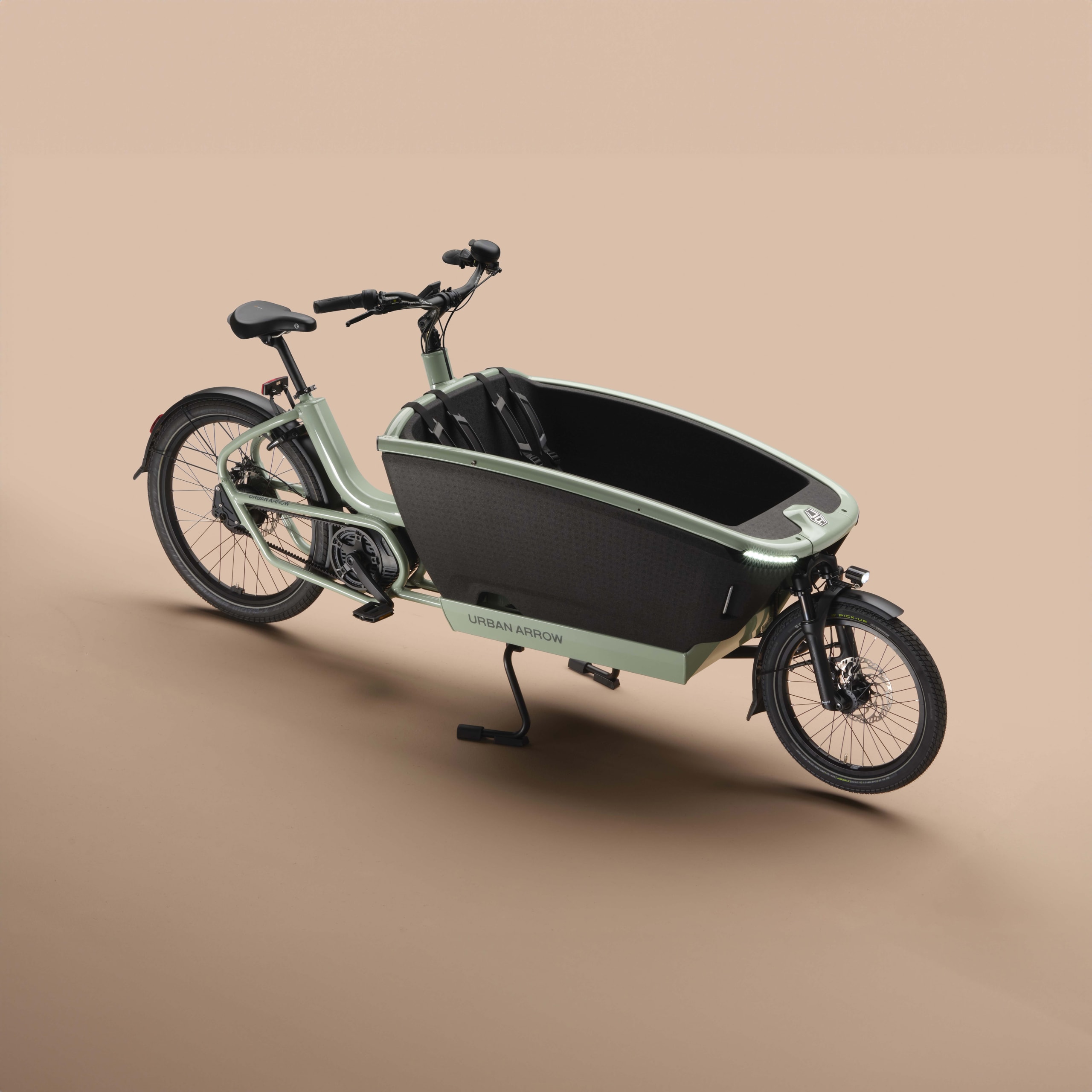 A green electric cargo bike with a large front storage compartment is displayed against a neutral background. The bike features two wheels, handlebars, and a pedal system.